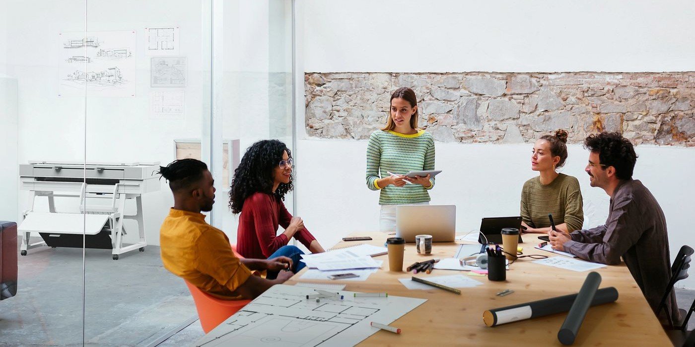 Equipo de trabajo con un plotter HP en el fondo