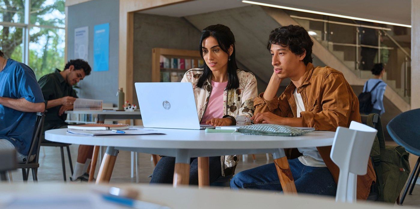 Estudiantes universitarios colaborando en proyectos académicos con laptop HP en biblioteca o área de estudio