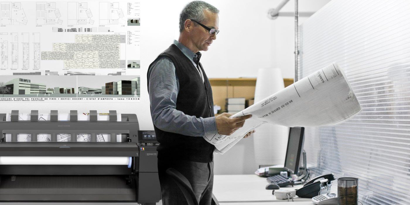 Arquitecto revisando un plano y con una impresora de gran fromato (plotter) HP al fondo.