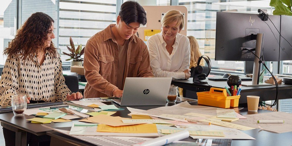 Tres colaboradores utilizando una estación de trabajo HP